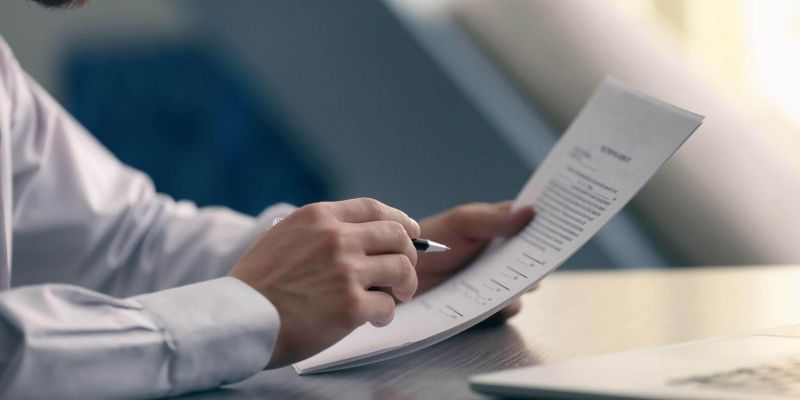 a man sitting at a desk with a pen and paper