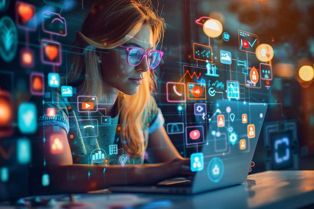 Woman with glasses using laptop, surrounded by colorful digital icons, representing technology and social media interaction.
