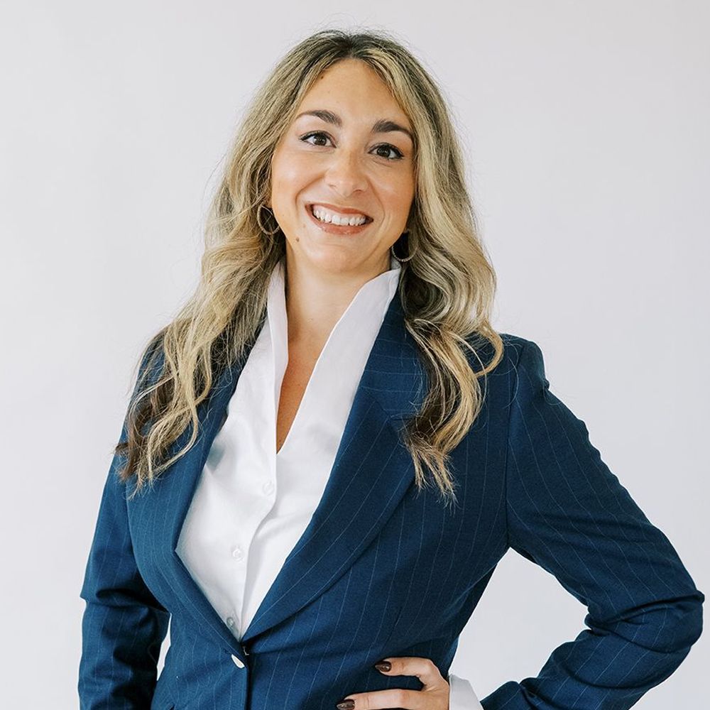 Jordan Griffin in a blue blazer with a white shirt, standing against a plain background.