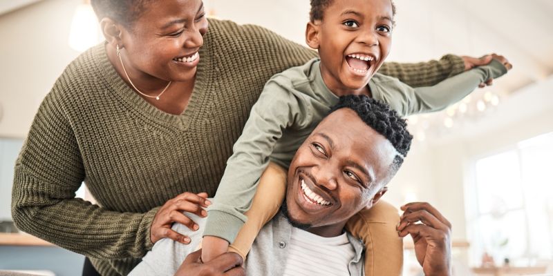 Happy family playing together indoors, parents and child smiling and having fun.