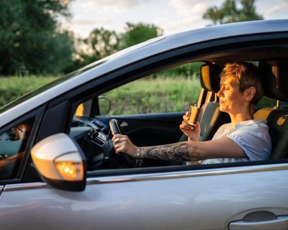 Man in car holding wine, relevant to DWI