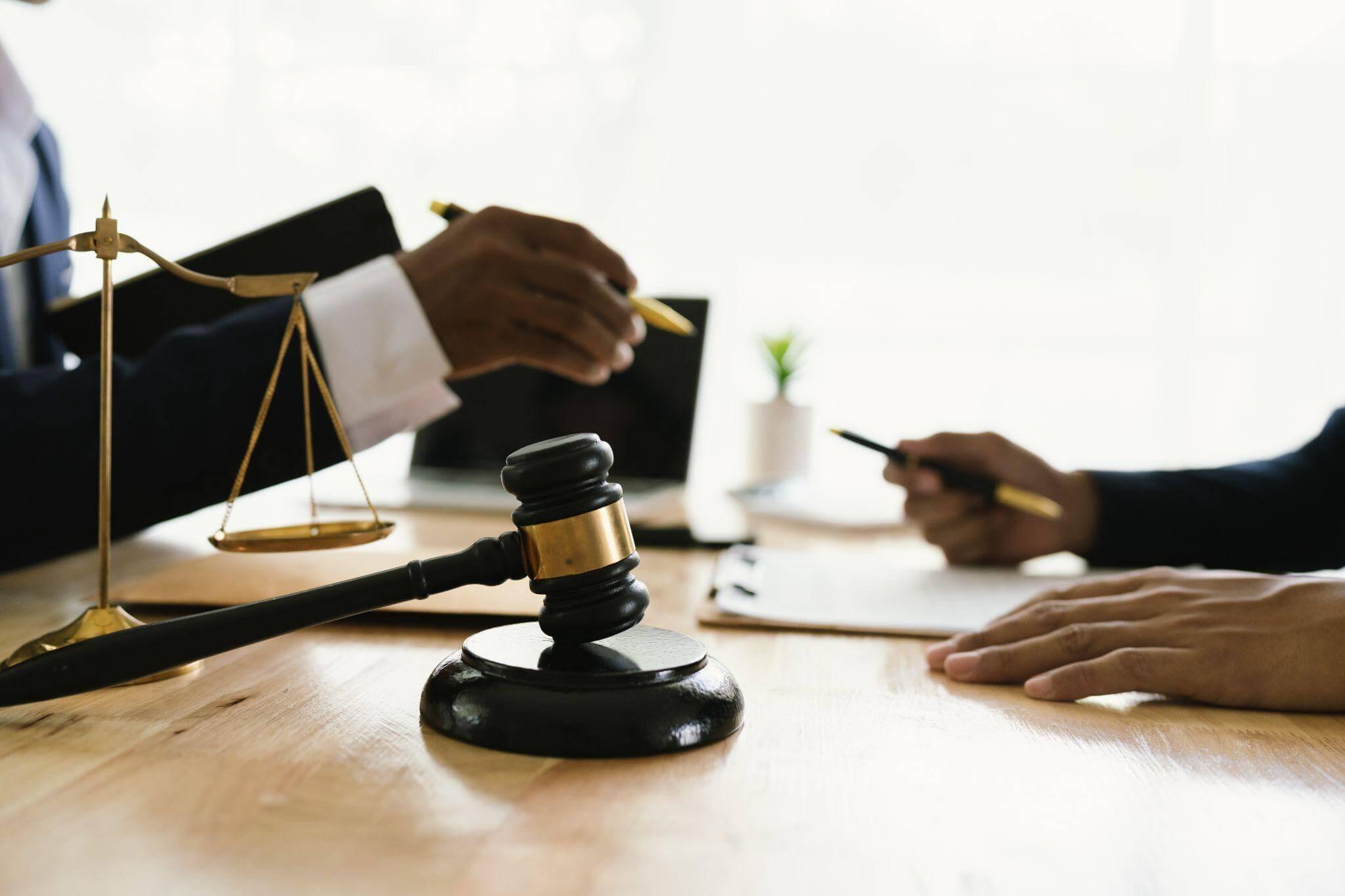 two people sitting at a table in front of a judge
