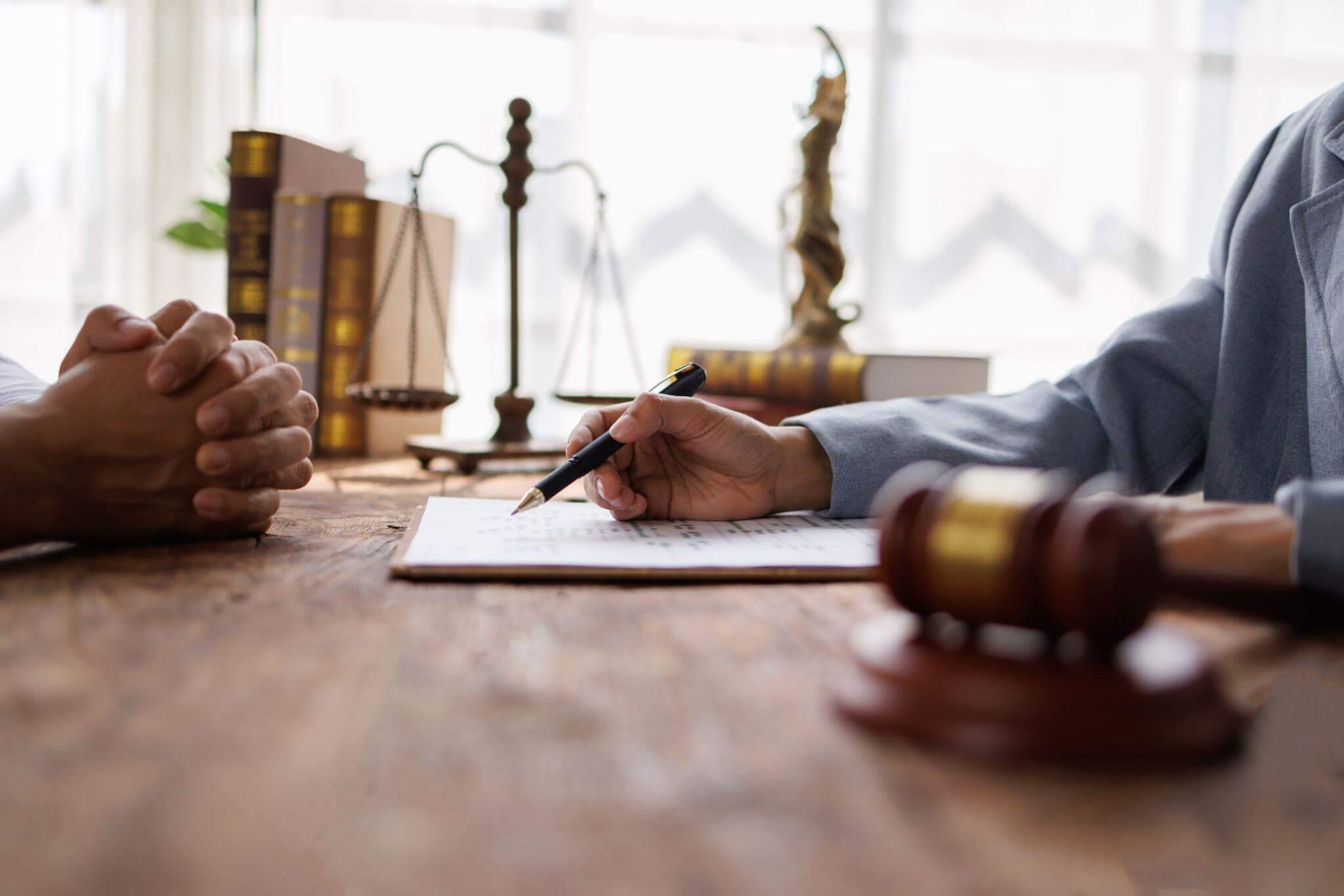 two people sitting at a table with a pen and paper