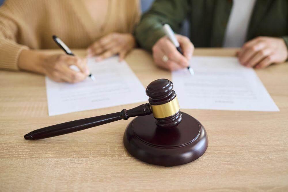 Two people at table with papers and gavel