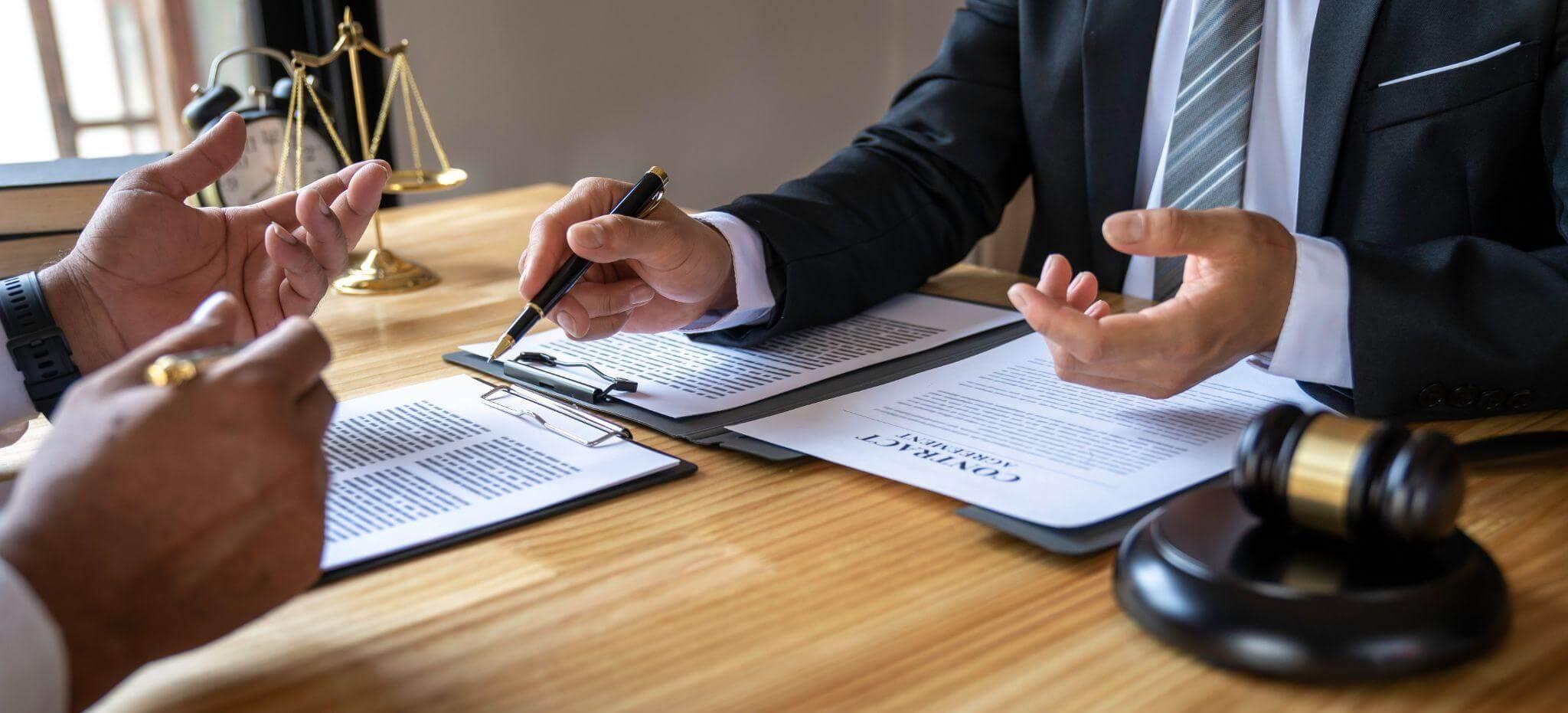 Client and attorney signing legal papers at a table in